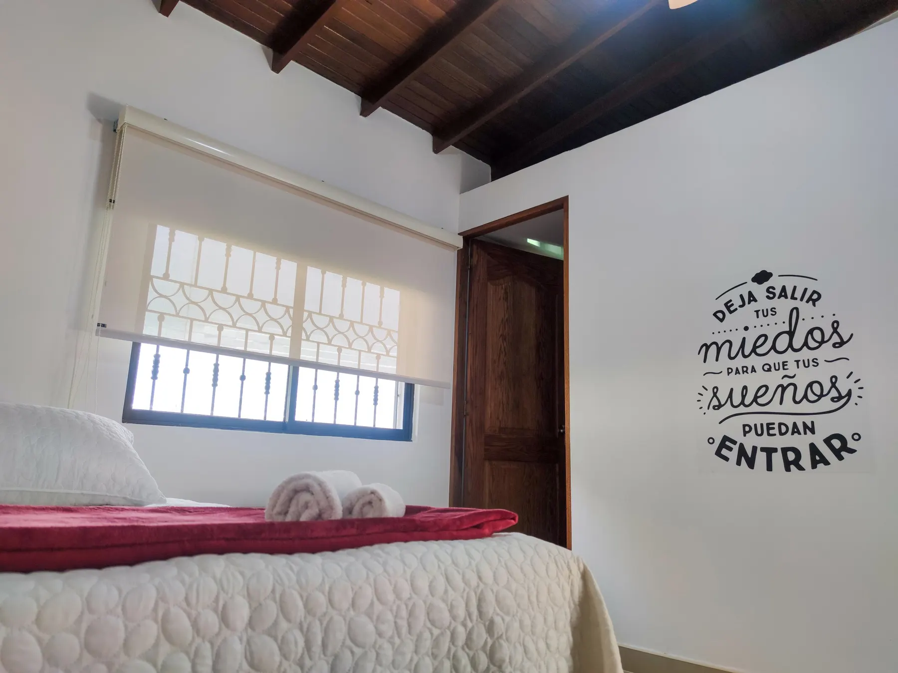 Chambre avec une armoire, un téléviseur et un autocollant mural inspirant