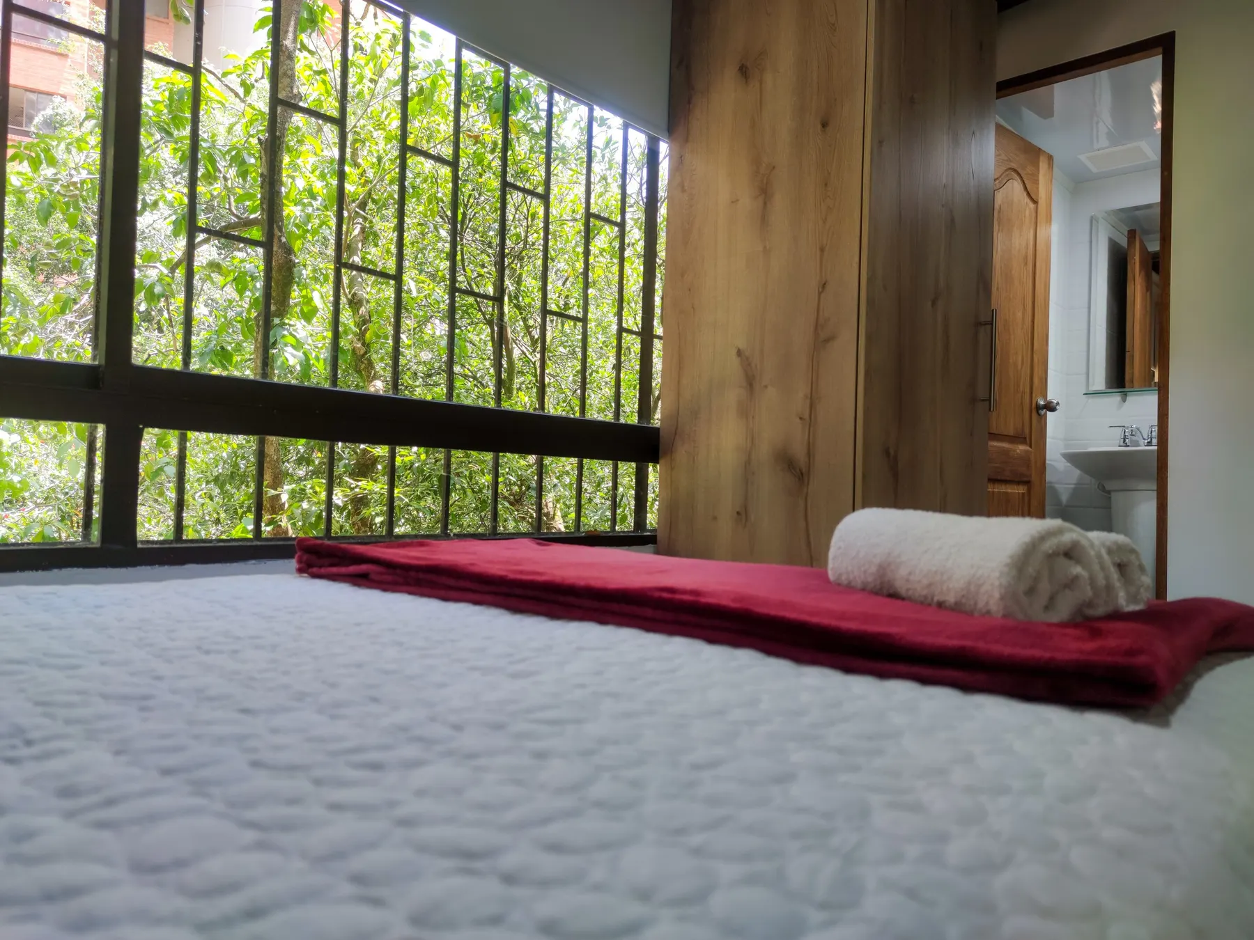 Chambre avec de grandes fenêtres donnant sur le jardin