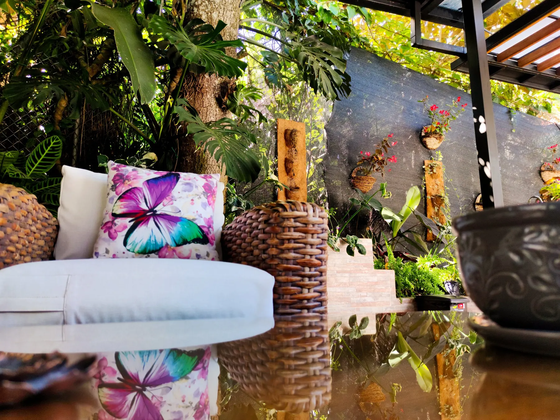 Coin détente du jardin avec des coussins, des plantes et des fleurs