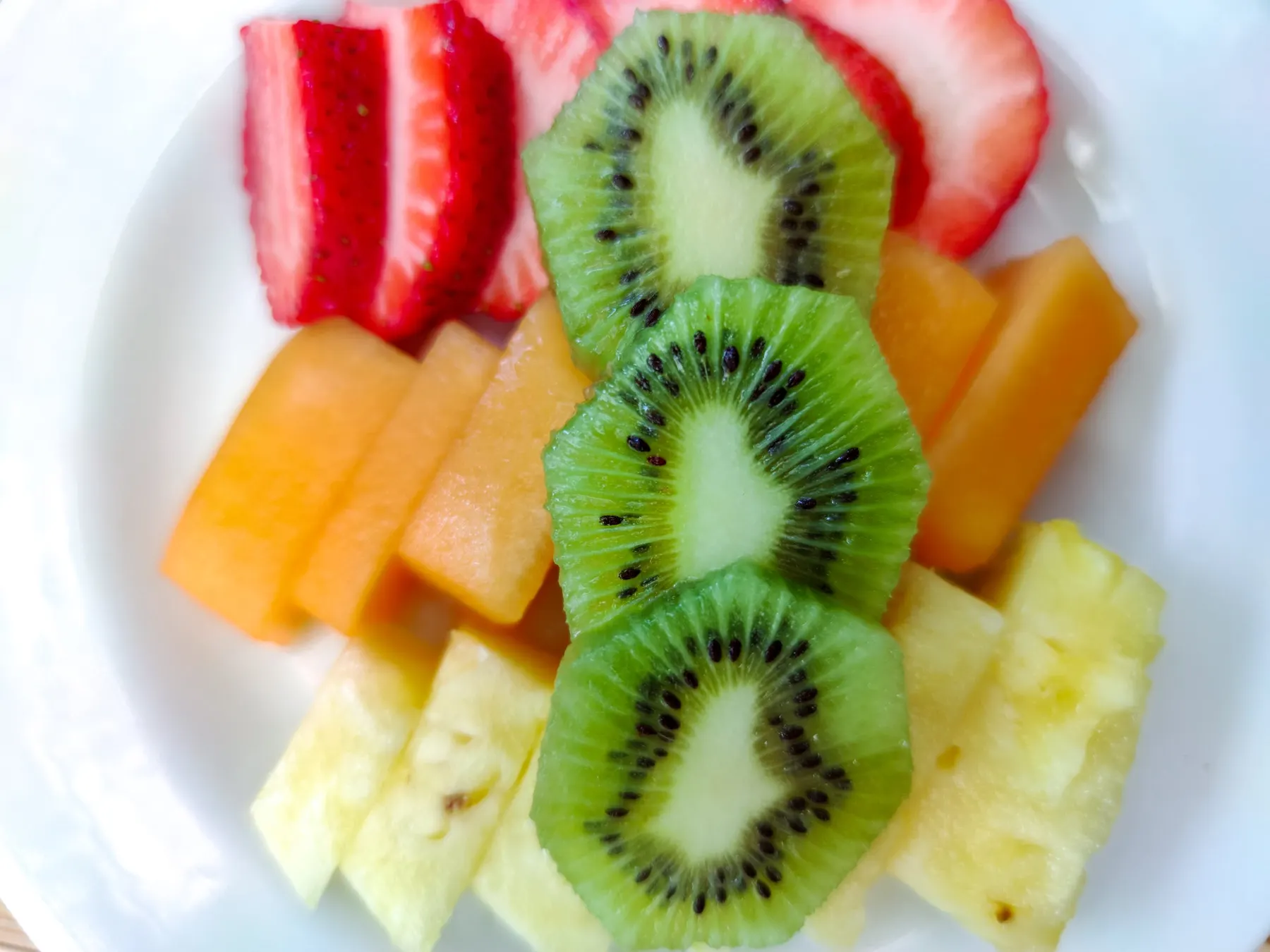 Assiette de fruits frais avec kiwi, fraise, melon et ananas